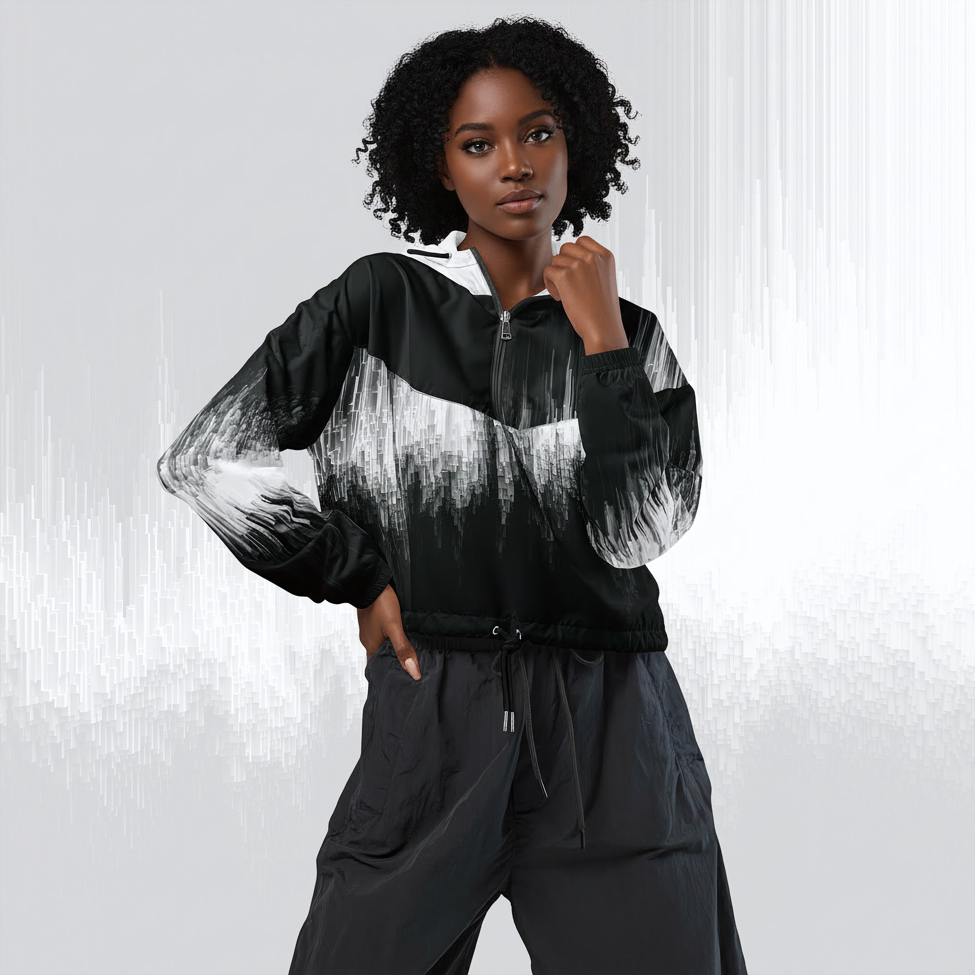 A model wearing a black and white abstract brushstroke print zip-up jacket and dark gray drawstring pants, posed against a light gray background with vertical light streaks.