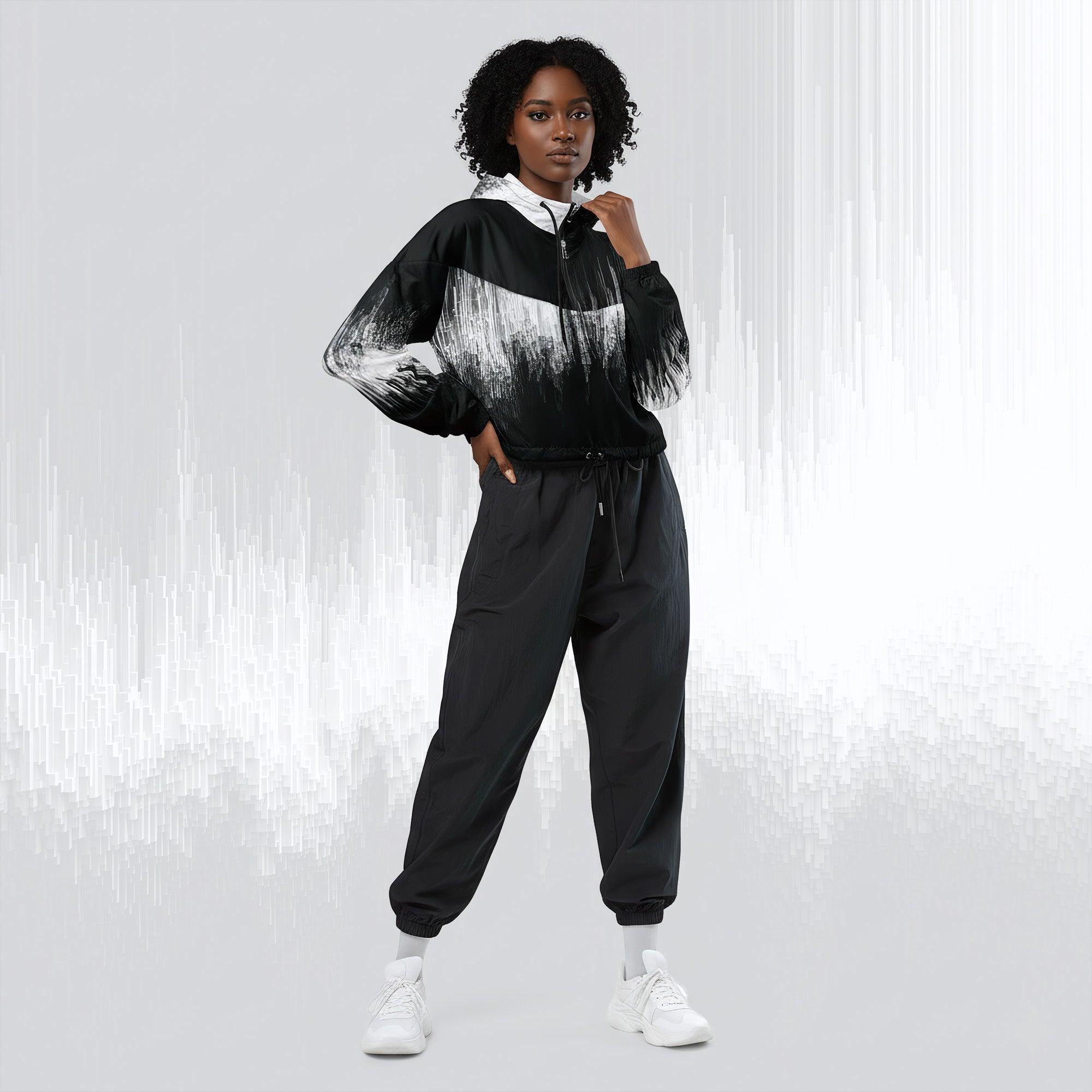 A model wearing a black and white abstract-patterned zip-up hoodie with black jogger pants and white sneakers, standing against a light gray background with vertical white streaks.