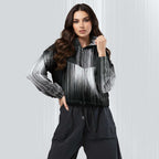 A woman modeling a black and white striped zip-up jacket with a gradient effect, paired with black pants, against a light gray textured studio background.