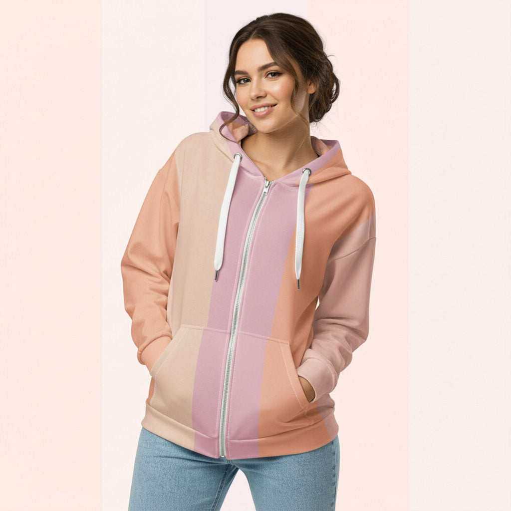 Front view of another woman wearing the Her Palette Strip Hoodie No. 05; pastel stripes cover the torso and sleeves, lavender hood lining and white zip, hands resting in the kangaroo pocket, pastel striped background from Form Finding Design.