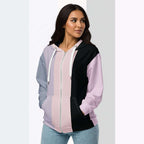 Three‑quarter side view of the second woman wearing the Her Palette Strip Hoodie No. 11; pastel vertical stripes accent the body and sleeves, lavender hood and white drawstrings, pastel striped backdrop, pocket detail visible from Form Finding Design.