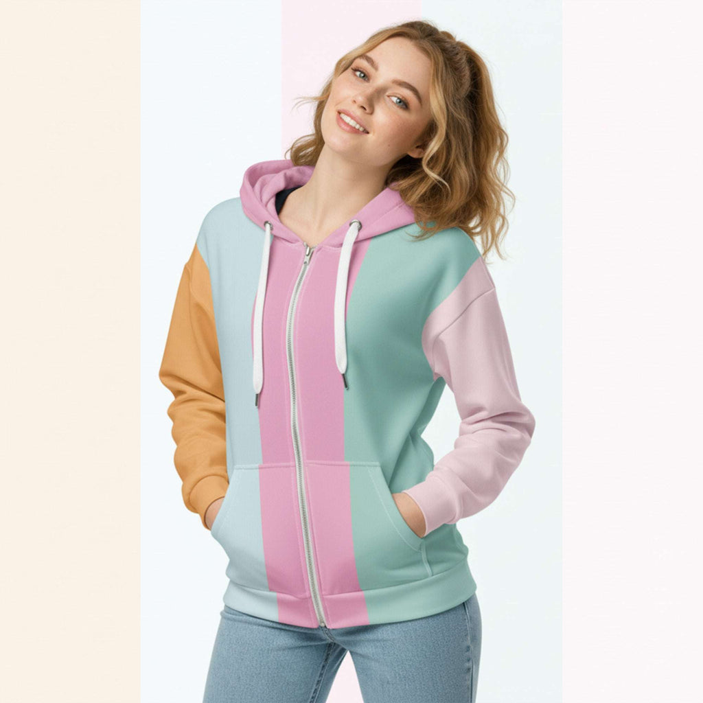 Front view of another woman wearing the Her Palette Strip Hoodie No. 13; pastel stripes cover the torso and sleeves, lavender hood lining and white zip, hands resting in the kangaroo pocket, pastel striped background from Form Finding Design.