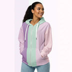 Three‑quarter side view of the second woman wearing the Her Palette Strip Hoodie No. 19; pastel vertical stripes accent the body and sleeves, lavender hood and white drawstrings, pastel striped backdrop, pocket detail visible from Form Finding Design.