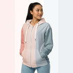 Three‑quarter side view of the second woman wearing the Her Palette Strip Hoodie No. 20; pastel vertical stripes accent the body and sleeves, lavender hood and white drawstrings, pastel striped backdrop, pocket detail visible from Form Finding Design.