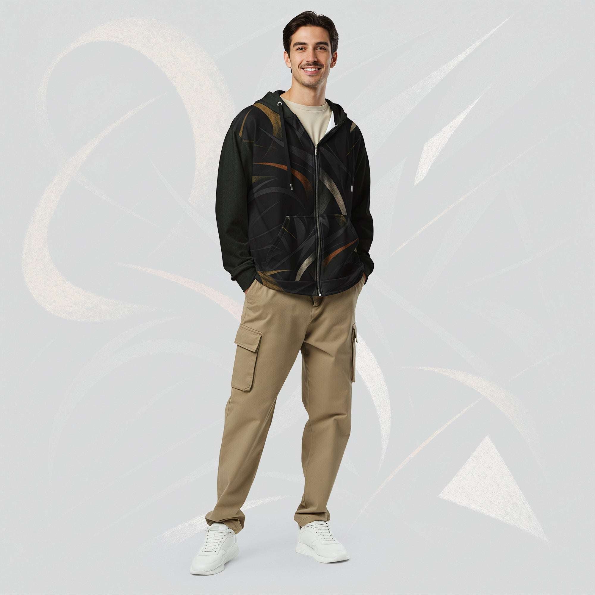 Front portrait of a male model wearing the Form Finding Design men’s Shadow Drip Hoodie (No.15), zipped up and hands by his sides; the hoodie’s abstract tan and olive print contrasts with his khaki cargo trousers, set against a pale grey background with faint curved motifs.