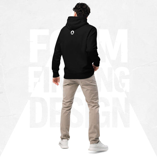 Back view on model in Form Finding Design Men’s Signature Hoodie (FFD-12), black—minimal back with small white circular emblem below the hood, paired with beige chinos and white trainers.