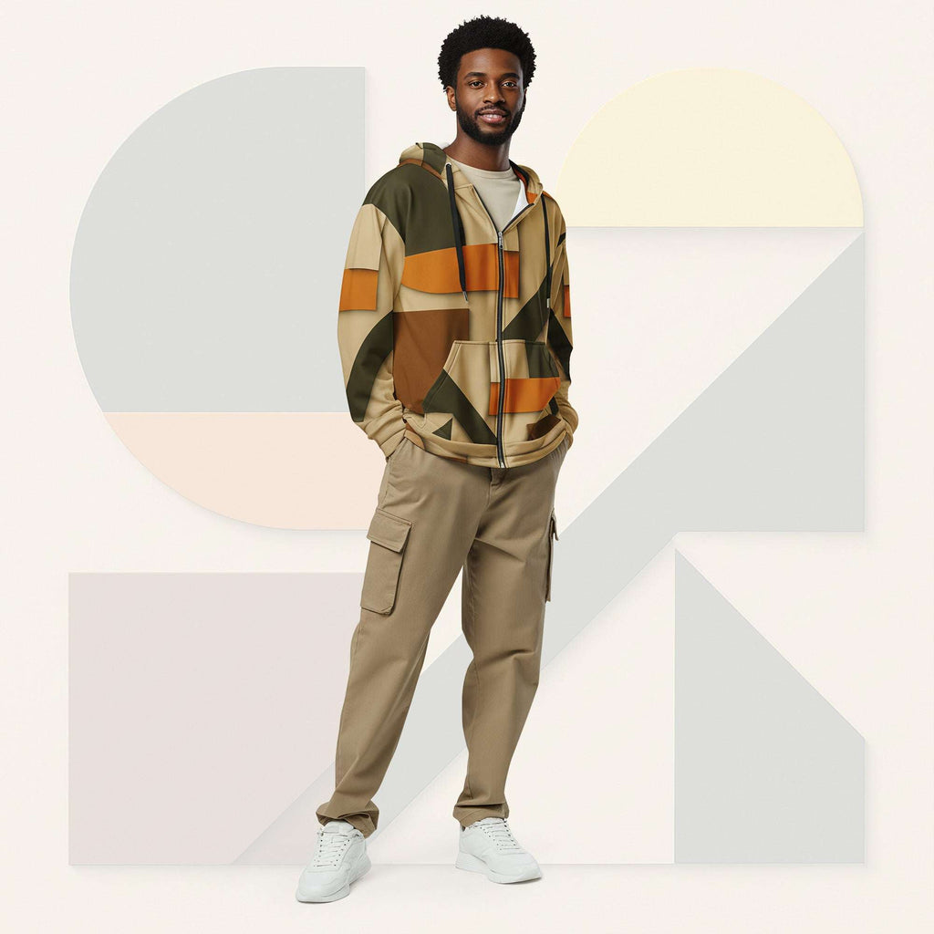 Male model wearing Form Finding Design Men’s Urban Utility Hoodie (No.07), front lifestyle portrait—earth-inspired geometric block print zip hoodie with kangaroo pockets and black drawstrings, styled with tan cargo trousers, minimalist architectural background.