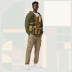 Male model wearing Form Finding Design Men’s Urban Utility Hoodie (No.12), front lifestyle portrait—earth-inspired geometric block print zip hoodie with kangaroo pockets and black drawstrings, styled with tan cargo trousers, minimalist architectural background.