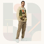 Male model wearing Form Finding Design Men’s Urban Utility Hoodie (No.18), front lifestyle portrait—earth-inspired geometric block print zip hoodie with kangaroo pockets and black drawstrings, styled with tan cargo trousers, minimalist architectural background.