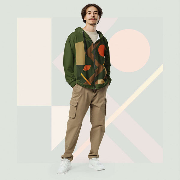 Male model wearing Form Finding Design Men’s Urban Utility Hoodie (No.19), front full-body—earth-tone geometric print zip hoodie with black drawstrings, styled with tan cargo trousers and white trainers, minimal architectural studio backdrop.