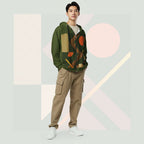 Male model wearing Form Finding Design Men’s Urban Utility Hoodie (No.19), front lifestyle portrait—earth-inspired geometric block print zip hoodie with kangaroo pockets and black drawstrings, styled with tan cargo trousers, minimalist architectural background.