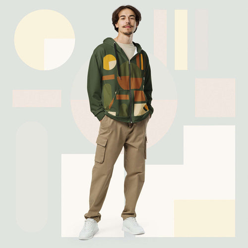 Male model wearing Form Finding Design Men’s Urban Utility Hoodie (No.20), front full-body—earth-tone geometric print zip hoodie with black drawstrings, styled with tan cargo trousers and white trainers, minimal architectural studio backdrop.
