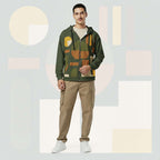 Lifestyle image of male model in Form Finding Design Men’s Urban Utility Hoodie (No.20), three-quarter stance—designer earth-palette geometric print highlighted across chest and sleeves, zip-front hoodie, neutral modern studio backdrop.