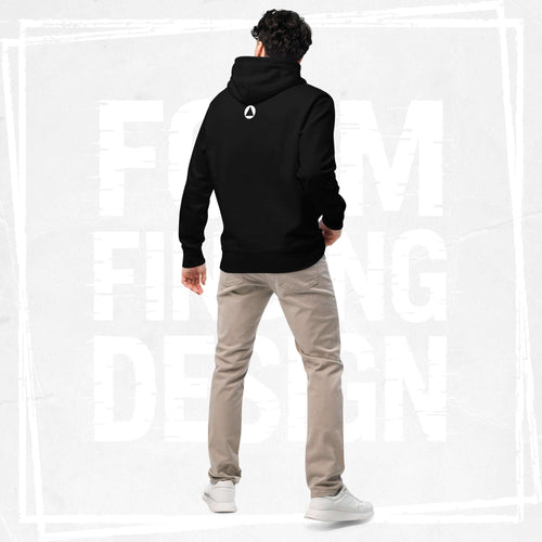 Back view on model in Form Finding Design Men’s Signature Hoodie (FFD-06), black—minimal back with small white circular emblem below the hood, paired with beige chinos and white trainers.