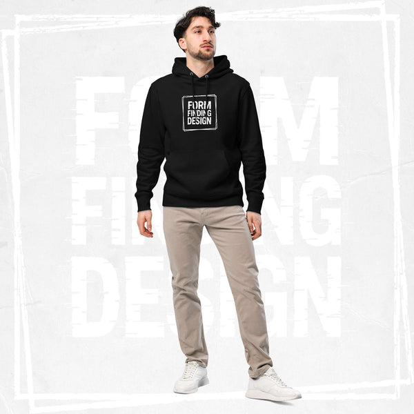 Male model wearing FormFD Men’s Signature Hoodie (FFD-06) in black with white square “FORM FINDING DESIGN” print, styled with beige chinos and white trainers, clean studio backdrop.