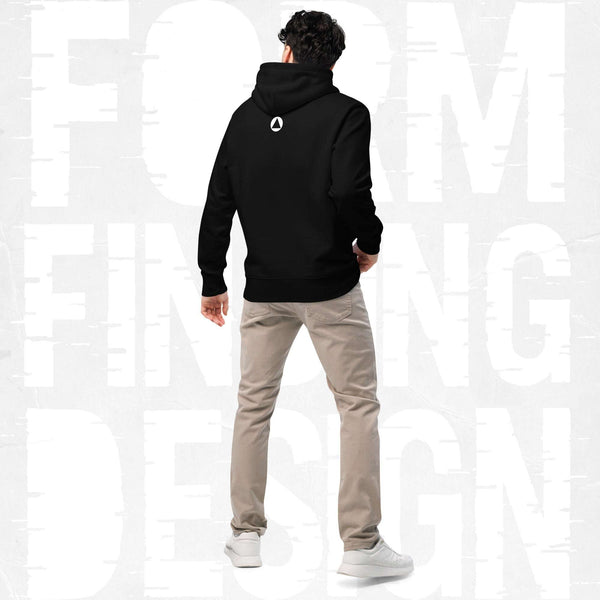 Back view on model in Form Finding Design Men’s Signature Hoodie (FFD-08), black—minimal back with small white circular emblem below the hood, paired with beige chinos and white trainers.