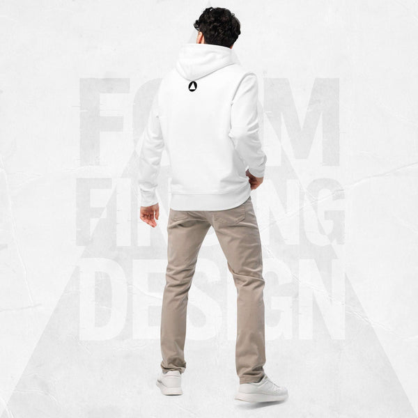 Back view on model in Form Finding Design Men’s Signature Hoodie (FFD-11), white—minimal back with small black circular emblem below the hood, paired with beige chinos and white trainers.v