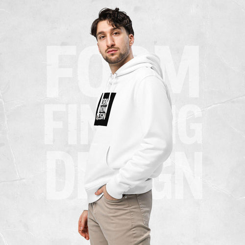 Three-quarter side portrait of male model in FormFD Men’s Signature Hoodie (FFD-13), white—hood drape, kangaroo pocket and partial chest logo visible, hand in pocket, beige chinos.
