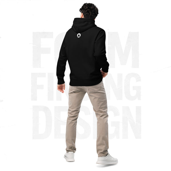 Back view on model in Form Finding Design Men’s Signature Hoodie (FFD-14), black—minimal back with small white circular emblem below the hood, paired with beige chinos and white trainers.