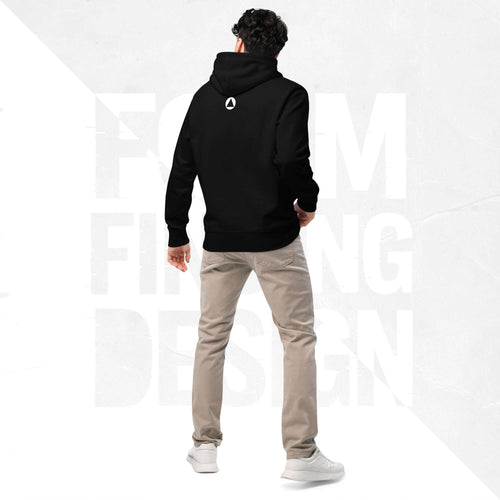 Back view on model in Form Finding Design Men’s Signature Hoodie (FFD-16), black—minimal back with small white circular emblem below the hood, paired with beige chinos and white trainers.