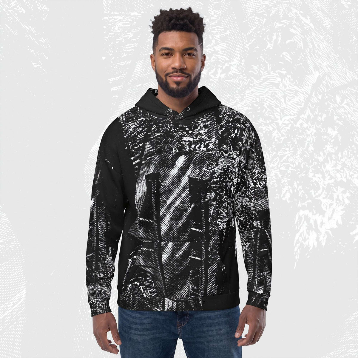 A man wearing the Stipple Bleed Print (No.02) with a drawstring hood, paired with blue jeans, standing against a light gray background with a faint graphic overlay.