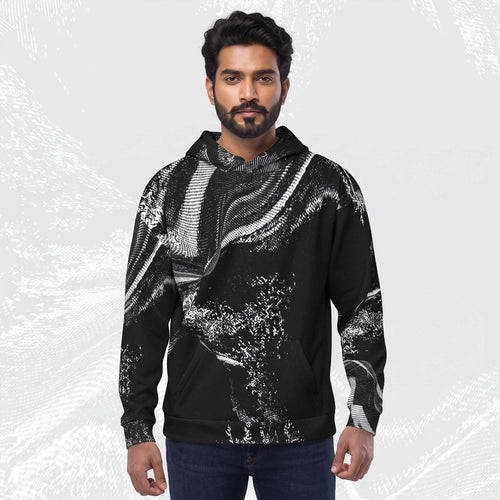 A man wearing a black pullover hoodie with a white abstract brushstroke pattern, paired with dark blue jeans, standing against a light gray textured background.