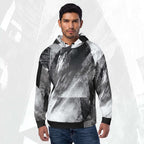 A man wearing a black, white, and gray abstract print hoodie with blue jeans, standing against a light gray background with a subtle cityscape graphic.
