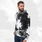 A man wearing a black and white abstract paint splatter hoodie with a gray hood lining, paired with blue jeans, set against a textured light gray background.