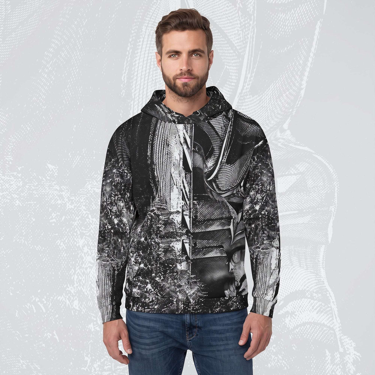 A man wearing a black and white abstract patterned zip-up hoodie with a drawstring hood, paired with blue jeans, standing against a light gray background with a faint graphic overlay.