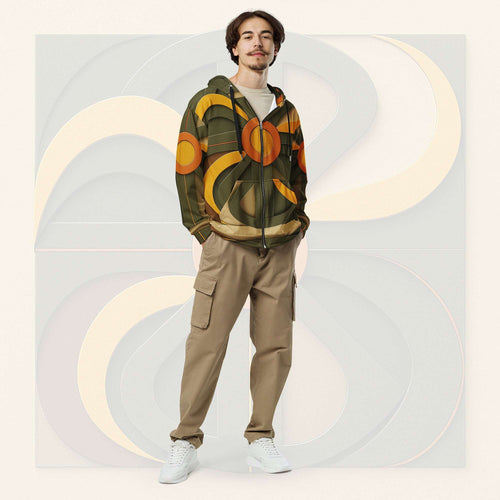 Male model wearing Form Finding Design Men’s Urban Utility Hoodie (No.03), front full-body—earth-tone geometric print zip hoodie with black drawstrings, styled with tan cargo trousers and white trainers, minimal architectural studio backdrop.