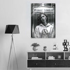 A black and white poster print of a woman in a futuristic helmet hanging on a light gray wall above a dark wood console table, styled in a modern room setting with a tripod floor lamp.