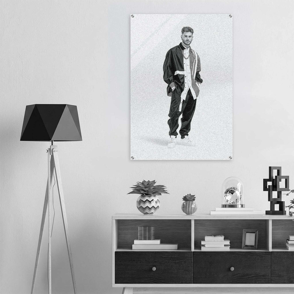 A black and white poster print of a man in a tracksuit hanging on a light gray wall above a modern white and dark wood console table, styled with a black tripod floor lamp and decorative plants.