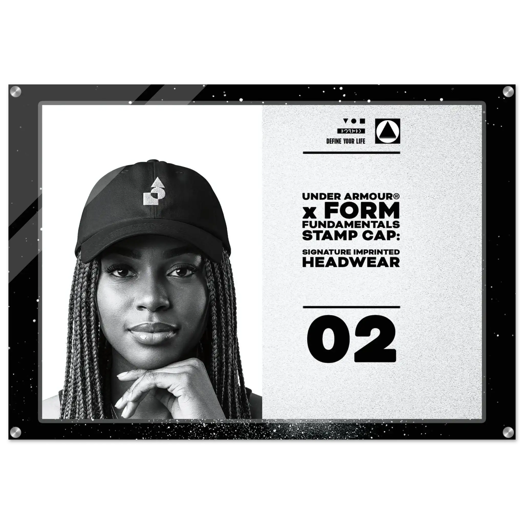 A framed black-and-white promotional print featuring a woman wearing a black Under Armour cap, with text reading 'FORM FUNDAMENTALS STAMP CAP: SIGNATURE IMPRINTED HEADWEAR' and the number 02.