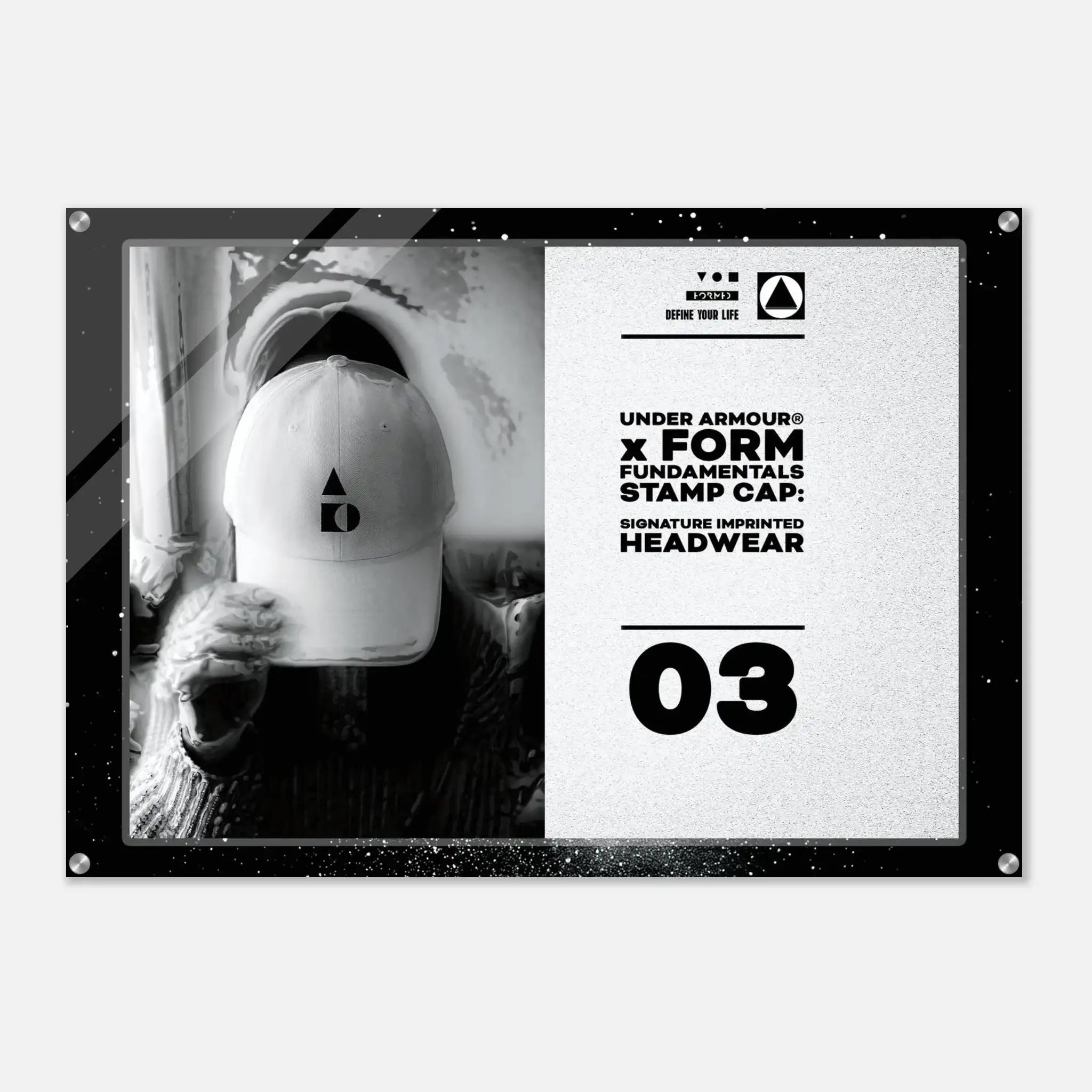 A rectangular acrylic wall art print with rounded corners and visible mounting hardware, featuring a black-and-white split design. The left side shows a monochrome photo of a person wearing a white cap, and the right side contains product text reading 'UNDER ARMOUR x FORM FUNDAMENTALS STAMP CAP' and '03'.