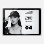 A black-framed acrylic wall plaque featuring a black-and-white portrait of a woman wearing a baseball cap, alongside text reading 'UNDER ARMOUR x FORM FUNDAMENTALS STAMP CAP' and 'SIGNATURE IMPRINTED HEADWEAR' with the number 04.