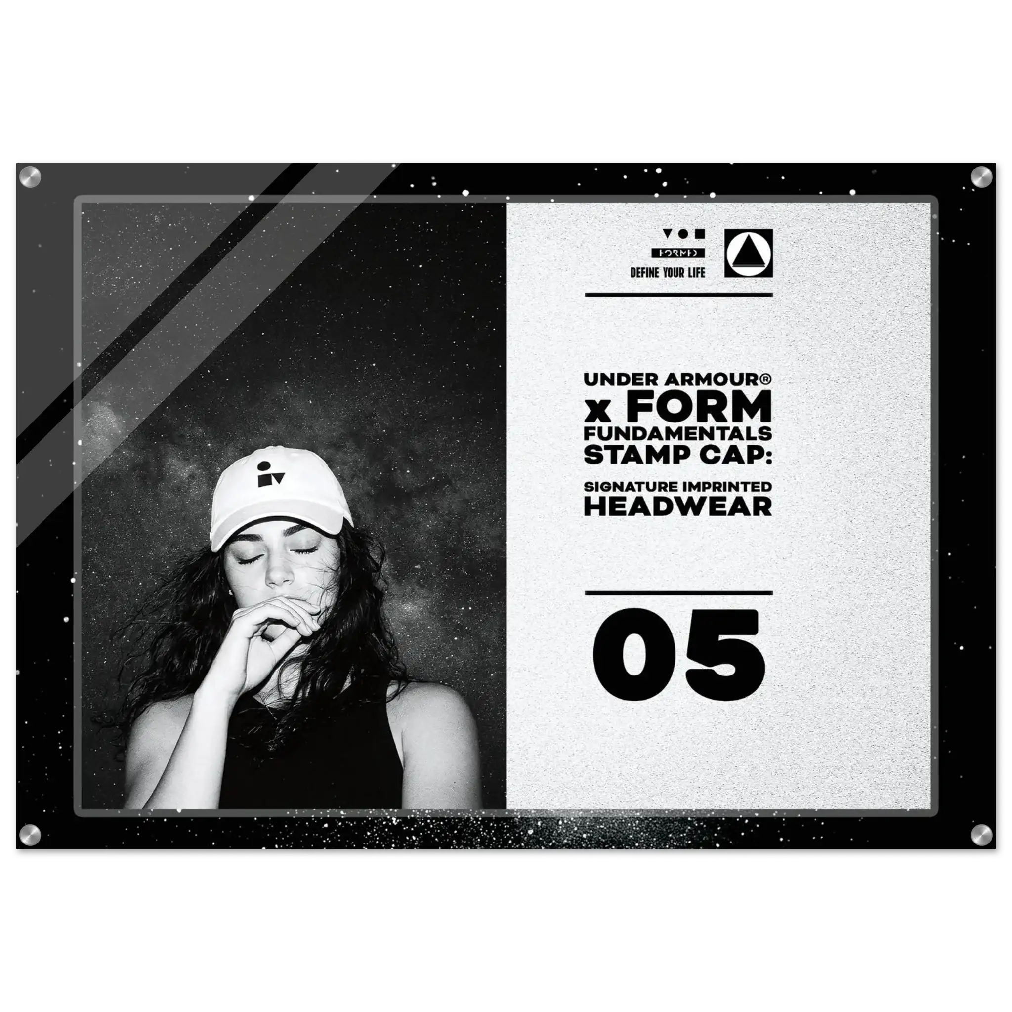 A framed monochrome promotional print or poster featuring a black-and-white portrait of a woman in a cap on the left and text on the right that reads 'UNDER ARMOUR x FORM FUNDAMENTALS STAMP CAP: SIGNATURE IMPRINTED HEADWEAR' with '05' below, shown against a light gray background.