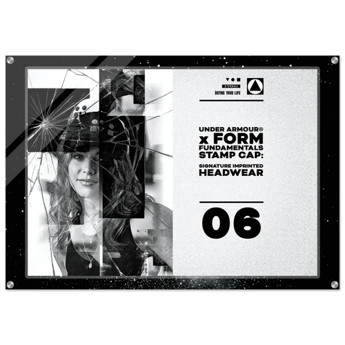A square black acrylic stamp cap featuring a split design: one side shows a black-and-white photo of a woman broken by a spiderweb graphic overlay, and the other side displays text including 'UNDER ARMOUR x FORM FUNDAMENTALS STAMP CAP', 'SIGNATURE IMPRINTED HEADWEAR', and '06'.