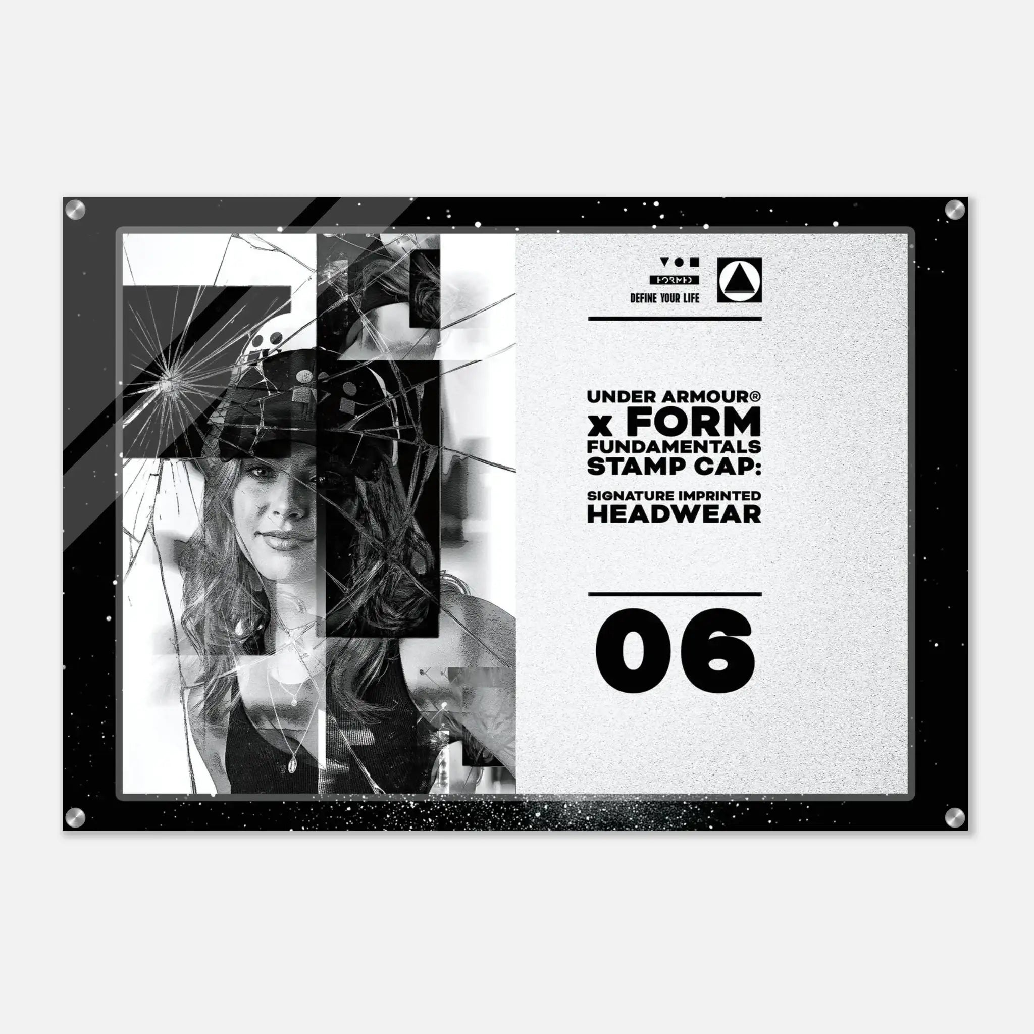 A rectangular acrylic wall art print with a black frame and silver corner hardware, featuring a black-and-white graphic design with text reading 'UNDER ARMOUR x FORM FUNDAMENTALS STAMP CAP: SIGNATURE IMPRINTED HEADWEAR' and the number '06'.