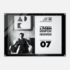A rectangular black-framed wall art print with a split design: the left side shows a black-and-white photo of a seated woman wearing a cap, and the right side has a light textured background with Under Armour branding, text reading 'FORM FUNDAMENTALS STAMP CAP,' and the number 07.