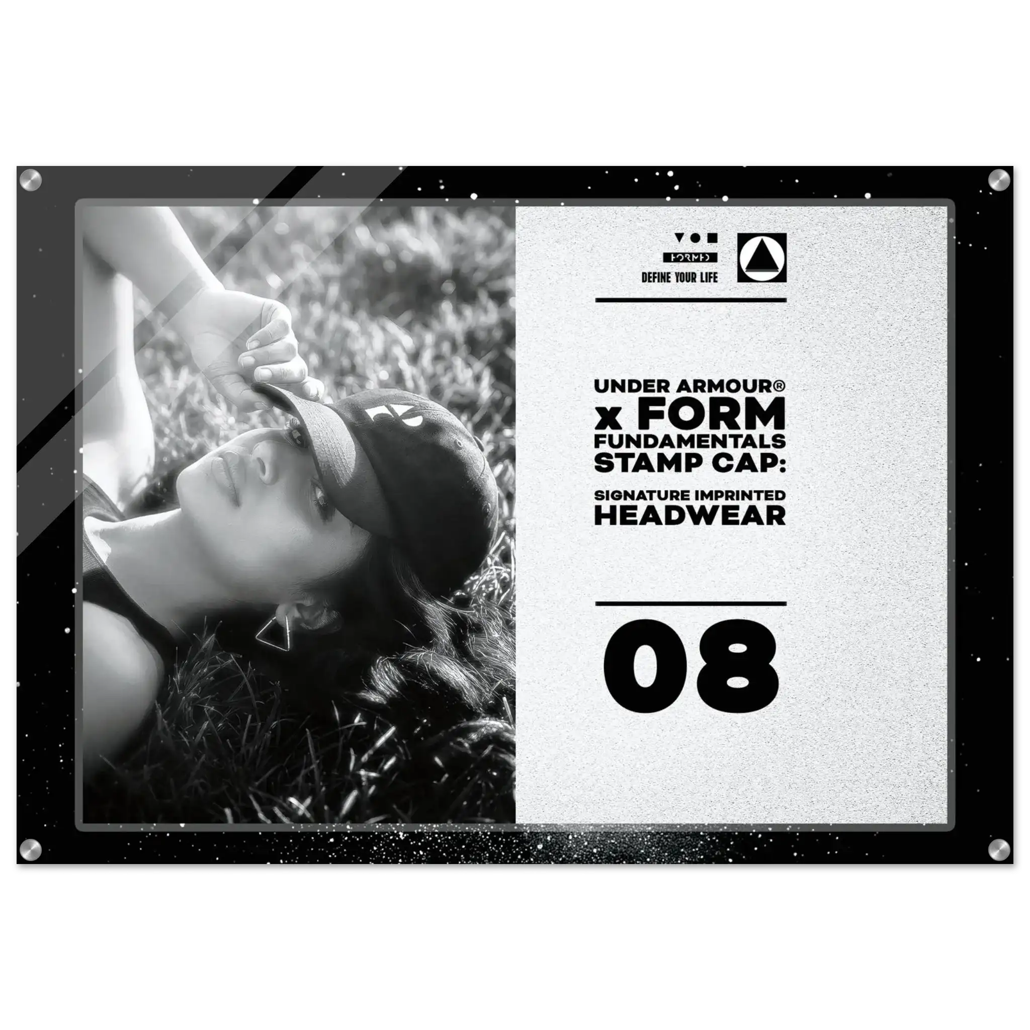 A framed black and white stamp cap design featuring a grayscale photo of a woman lying in grass, alongside text reading 'UNDER ARMOUR x FORM FUNDAMENTALS STAMP CAP: SIGNATURE IMPRINTED HEADWEAR' and the number '08'.
