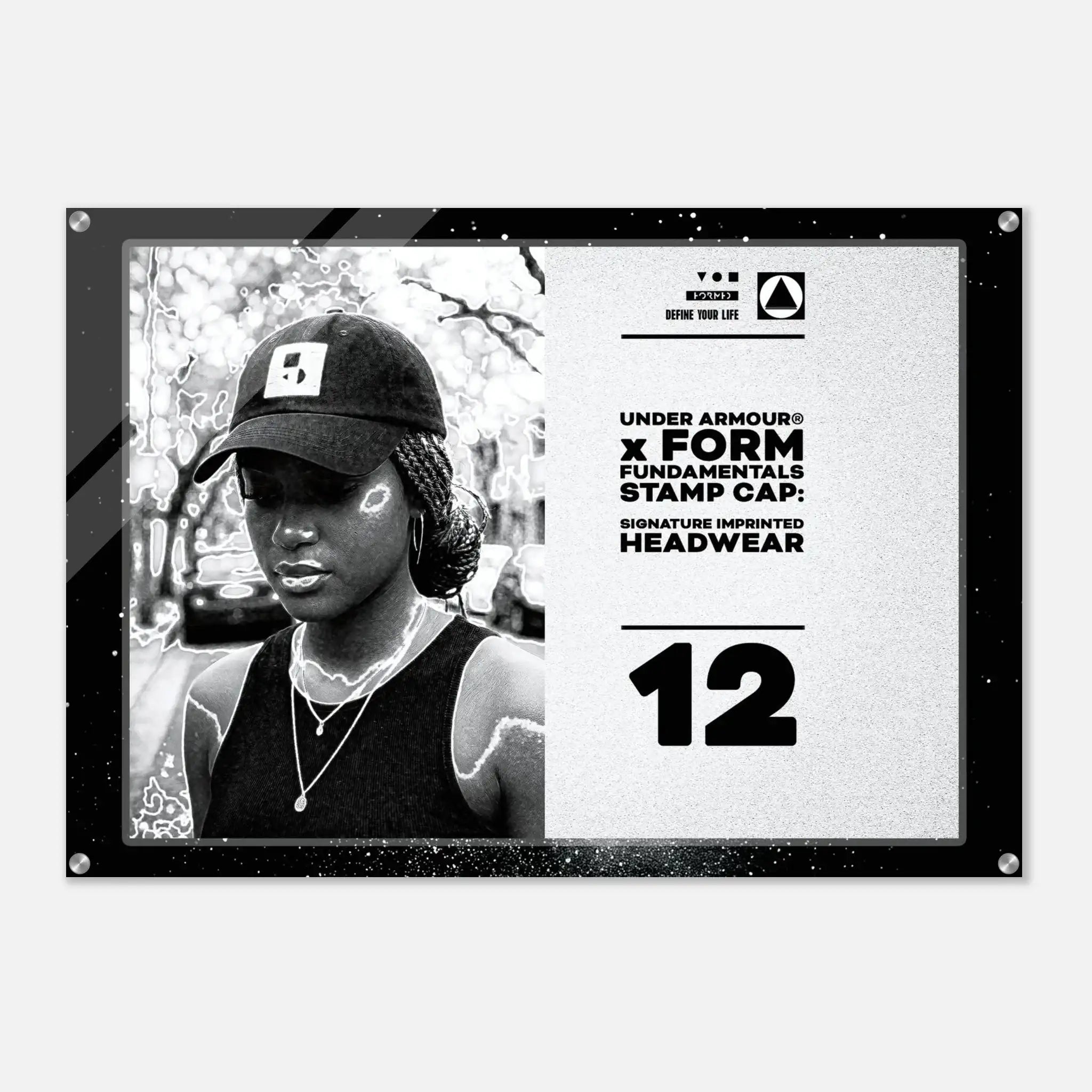 A black and white Under Armour x Form Fundamentals stamp cap design poster or print, featuring a black-and-white portrait of a woman wearing a cap on the left and product text including 'UNDER ARMOUR x FORM FUNDAMENTALS STAMP CAP' and 'SIGNATURE IMPRINTED HEADWEAR' on the right, all enclosed in a black frame with visible corner hardware.