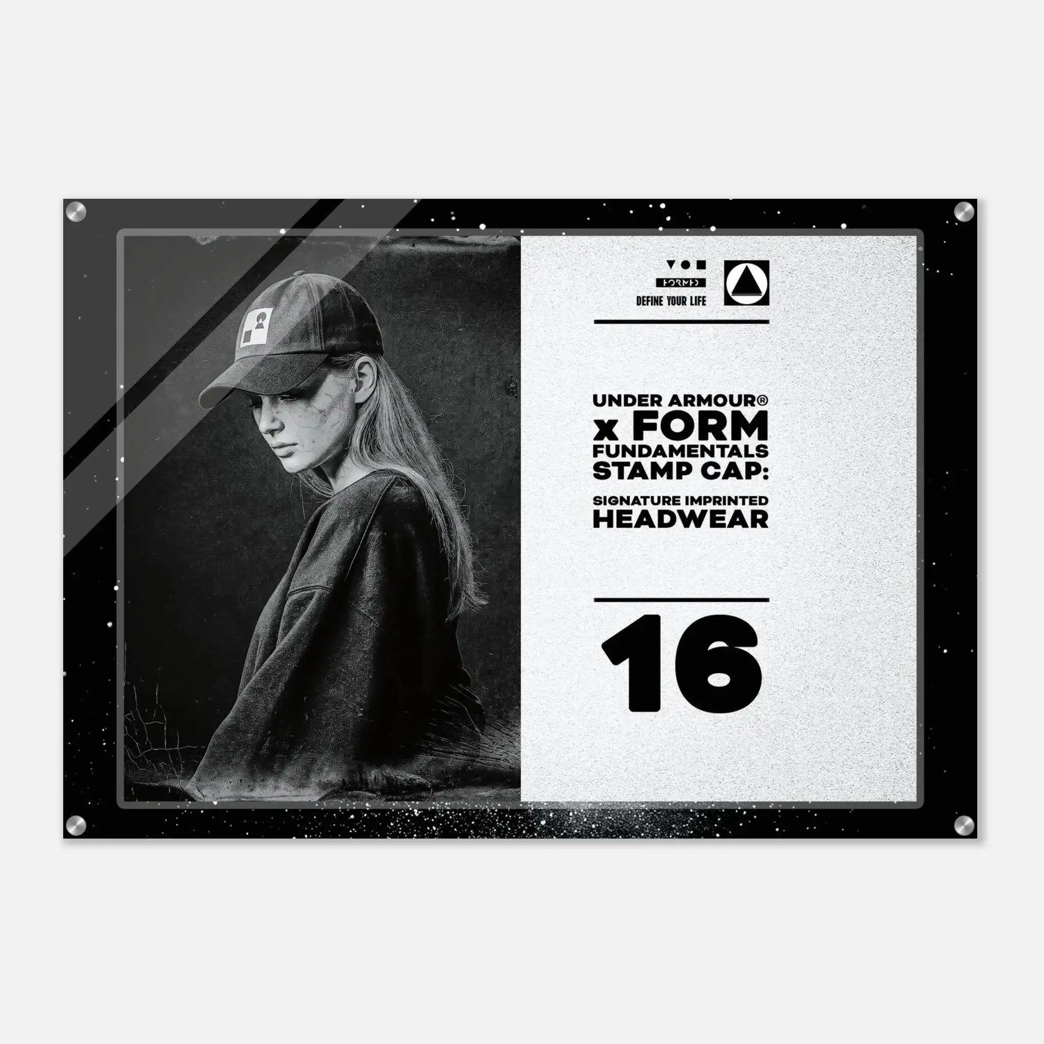 A rectangular acrylic wall art print featuring a black-and-white portrait of a woman wearing a baseball cap on the left, with text on the right that reads 'UNDER ARMOUR x FORM FUNDAMENTALS STAMP CAP' and 'SIGNATURE IMPRINTED HEADWEAR' above a large '16'. The print is shown against a light gray background with a subtle drop shadow.