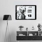 A framed black-and-white poster hangs on a light gray wall above a white and dark wood console shelf, next to a black geometric floor lamp. The poster features a monochrome portrait, bold text from Form Finding Design (FormFD).