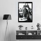 Framed photo of a woman sitting outdoors with decorative items on a shelf below.
