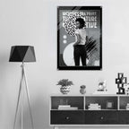 Poster with a woman's face and text on a wall above a shelf with decor items.