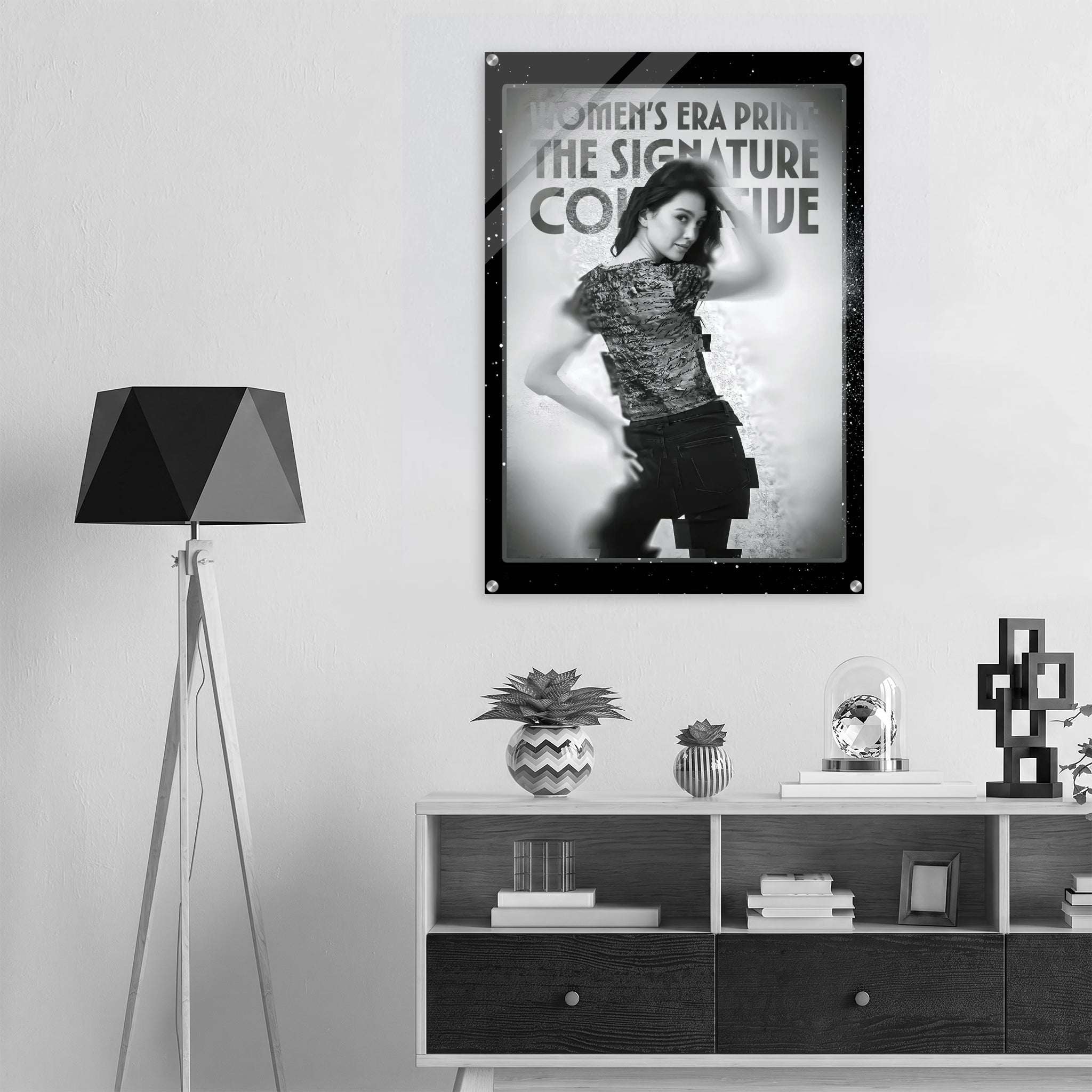 Framed poster of a woman in a stylish pose on a wall above a shelf with decor items.