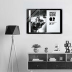 Framed poster on a wall above a shelf with decorative items