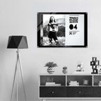 Framed artwork on a wall above a shelf with decorative items