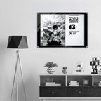 Framed artwork on a wall above a shelf with decorative items