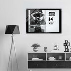 Framed artwork on a wall above a shelf with decorative items